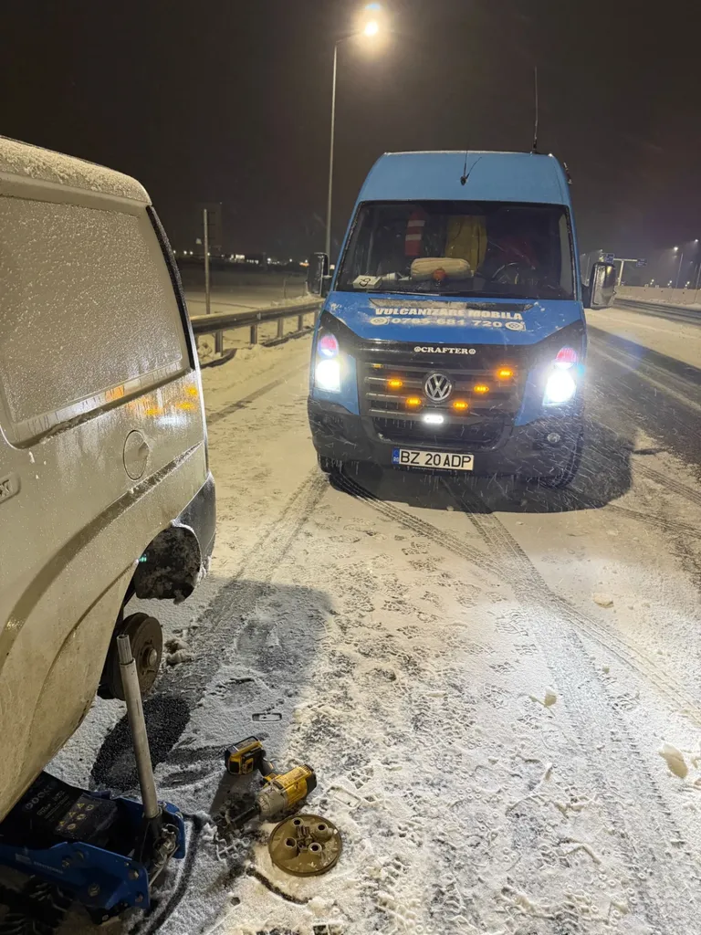 Intervenție de vulcanizare mobilă pe timp de iarnă, cu zăpadă și utilaje lângă autoutilitară